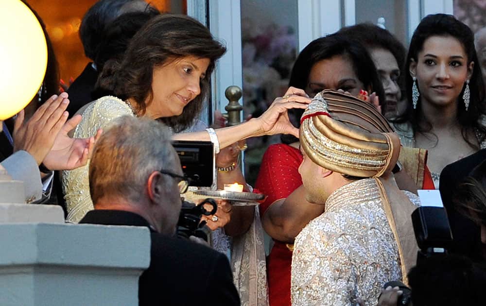 Kunal Grover son of London-based industrialists Kimi and Pamela Grover is attended to by his mother, left, prior to the wedding parade in Cannes, southern France.