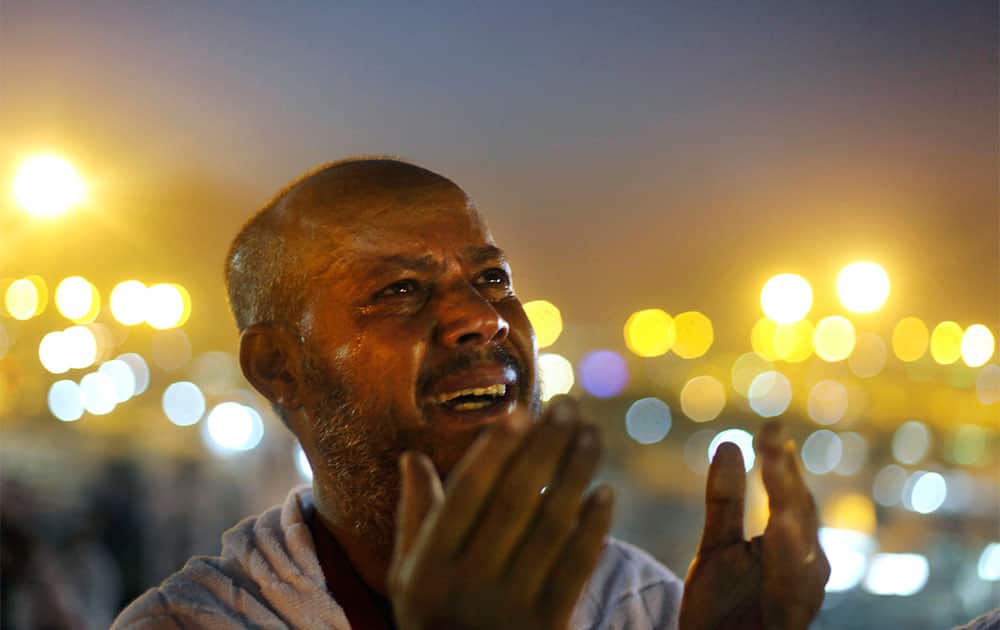 An Egyptian Muslim pilgrim cries as he prays at sunrise on a rocky hill called the Mountain of Mercy, on the Plain of Arafat near the holy city of Mecca, Saudi Arabia.