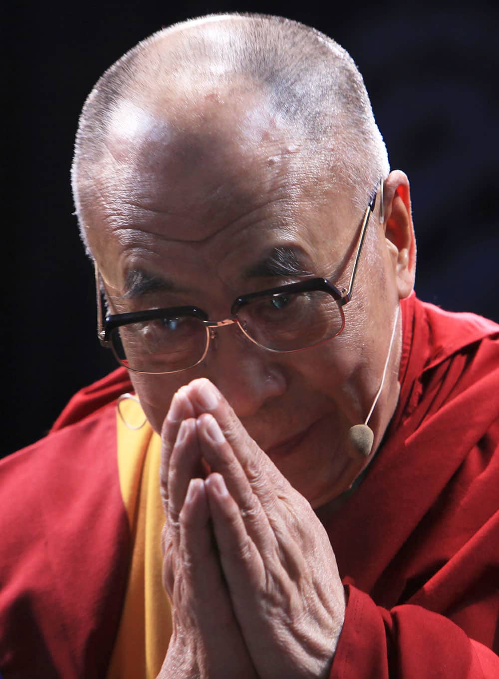 Tibet`s spiritual leader the Dalai Lama offers a greeting as he arrives during a ceremony at a theater in Mexico City.