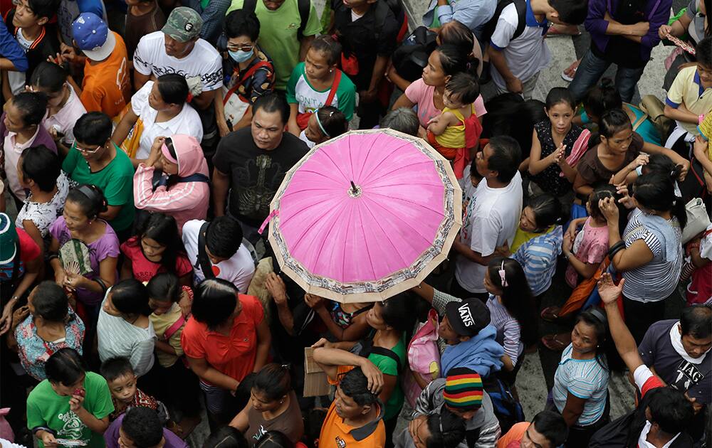 Thousands of residents, mostly affiliated with the Christian sect the Iglesia Ni Cristo (Church of Christ), gather at an intersection to receive relief supplies from one of the Philippines` largest Christian sects, in Manila.