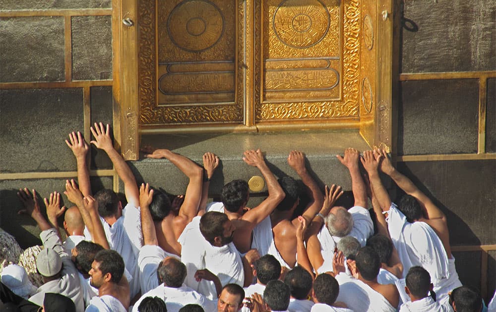 Muslim pilgrims pray at the door of the Kaaba, the cube-shaped structure in the Grand Mosque, that Muslims around the world face in prayer five times a day, in the Muslim holy city of Mecca, Saudi Arabia.
