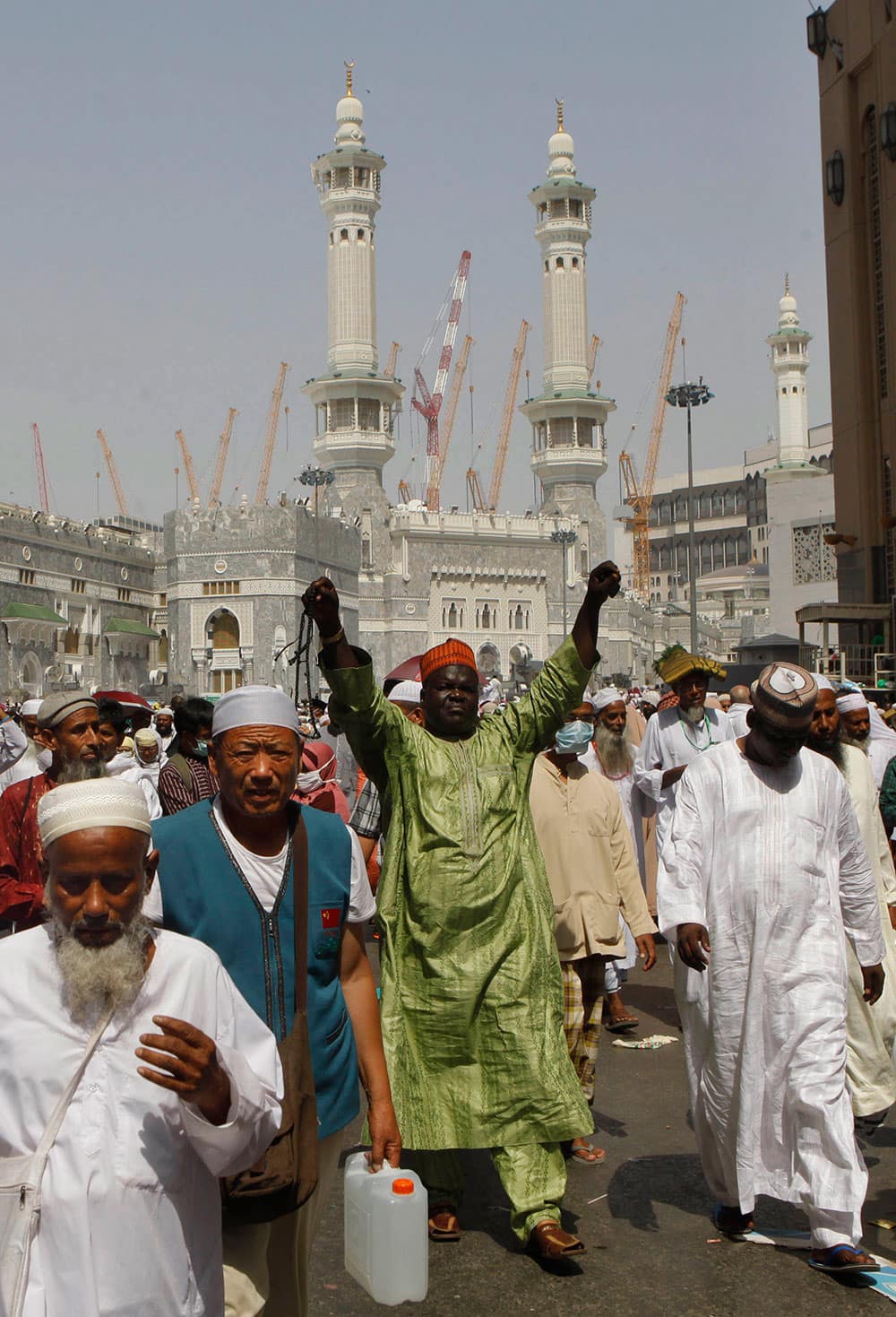 A Nigerian pilgrim adjusts his clothes as he and others leave Friday prayers at the Grand Mosque in the Muslim holy city of Mecca, Saudi Arabia.