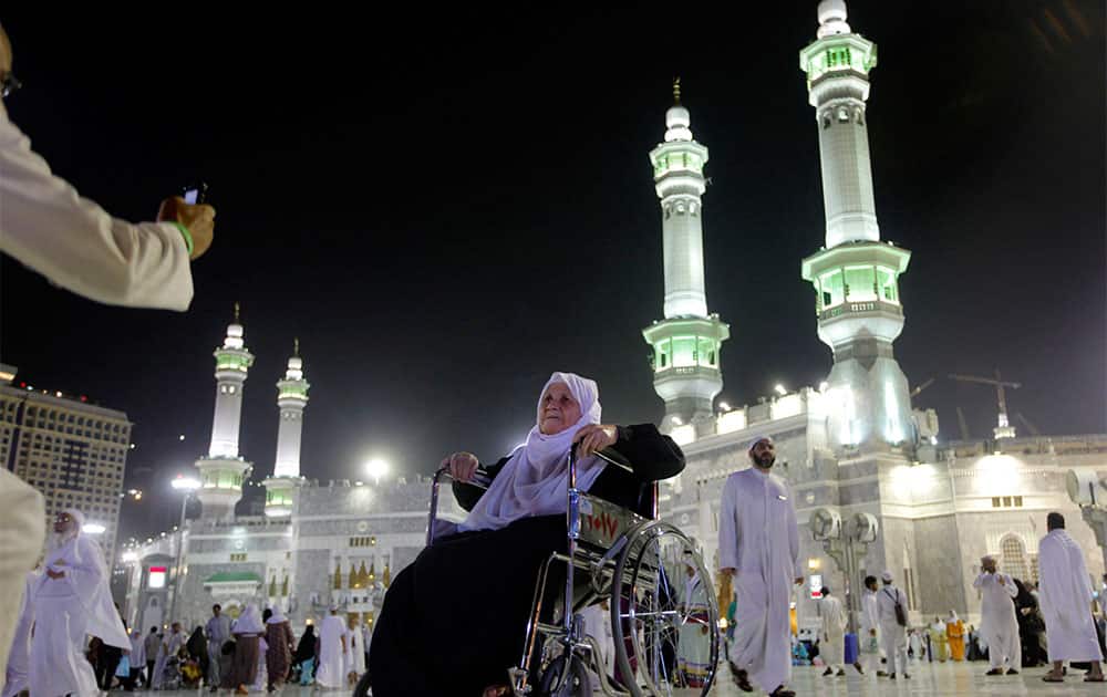 An elderly Muslim pilgrim poses for a picture in front of the Grand Mosque in the holy city of Mecca, Saudi Arabia.