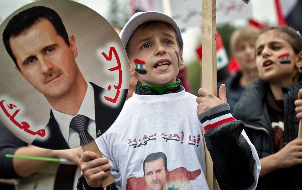 Children of the Syrian community in Romania shout pro-regime slogans while holding pictures of Syrian President Bashar Assad, during a demonstration in Bucharest, Romania.