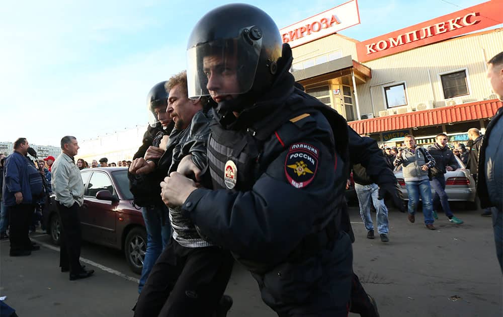 Police officers detain a protester in Moscow, Russia. The fatal stabbing of an ethnic Russian man has ignited anger in Moscow against people from the Caucasus, with demonstrators breaking into a shopping center and storming a vegetable warehouse Sunday evening.