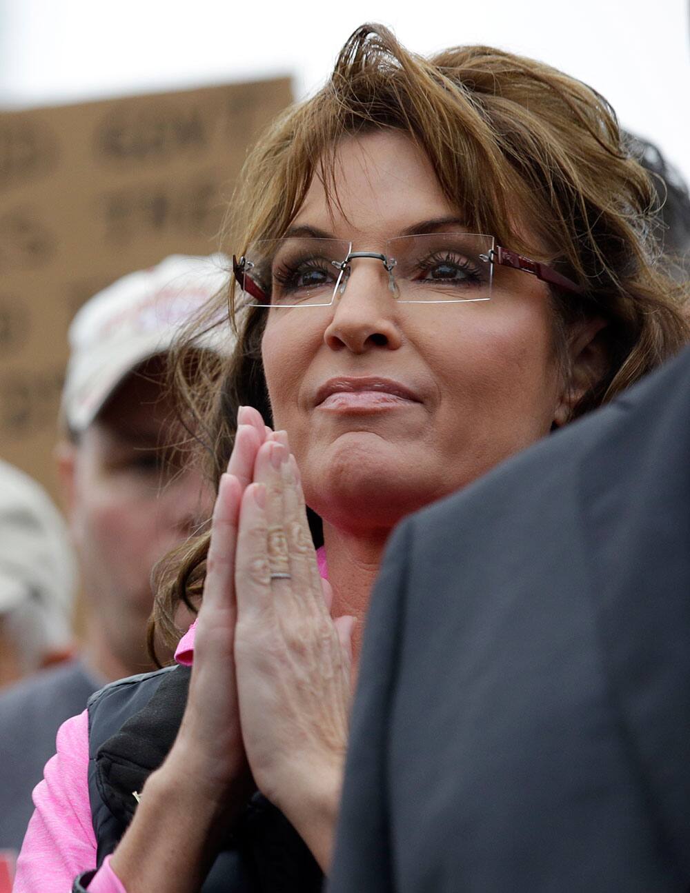 Tea Party activist and former Alaska Gov. Sarah Palin listens to a speaker at a rally at the World War II Memorial in Washington as leaders in the US Senate have taken the helm in the search for a deal to end the partial government shutdown and avert a federal default.