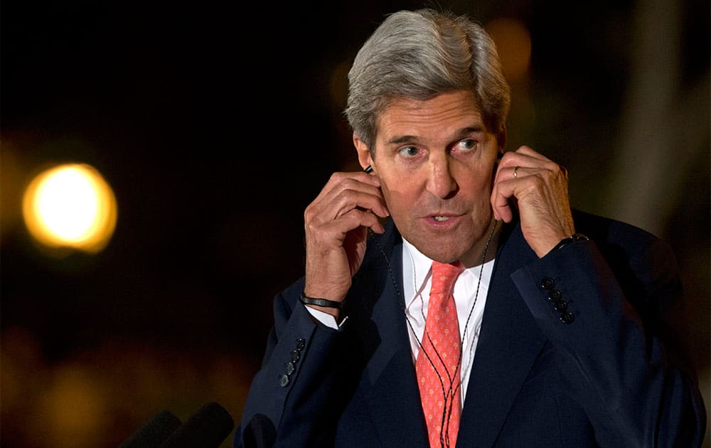 US Secretary of State John Kerry adjusts his translation headphones at a news conference with Afghan President Hamid Karzai at the Presidential Palace during an unannounced stop in Kabul, Afghanistan, as a deadline approaches for a security deal about the future of US troops in the country.