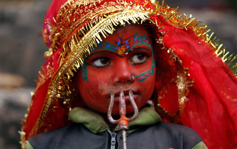 A child dressed like Hindu goddess Kali stands at the steps leading to a Hindu temple during “Navratri,” or nine nights festival, in Jammu.