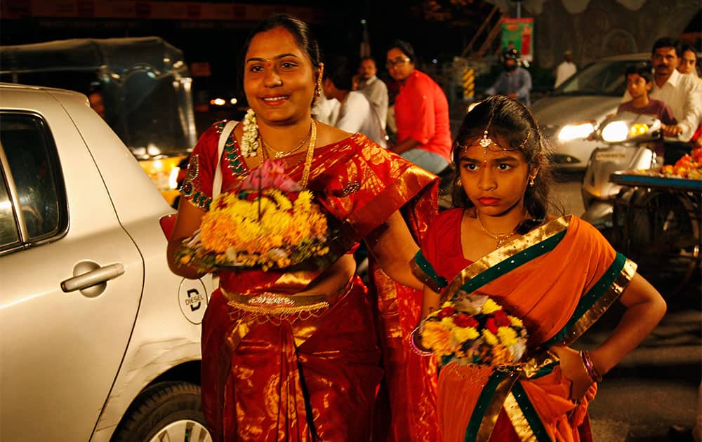 An Indian woman carries Bathukammas, floral arrangement representing the giver of life, during the Bathukamma festival dedicated to the Hindu Goddes Gauri in Hyderabad.