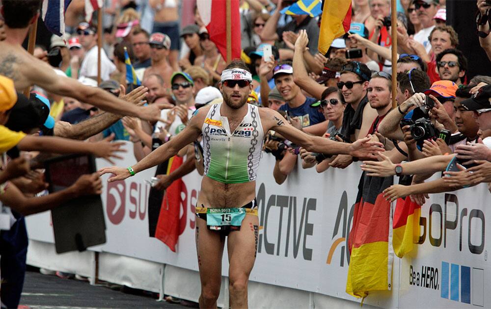 Faris Al-Sultan, of Germany, crosses the finish line to place tenth in the Ironman World Championship Triathlon in Kailua-Kona, Hawaii.