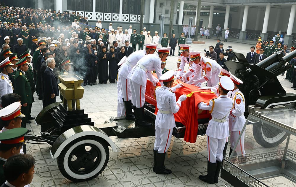 Members of a Vietnamese honor guard place the national flag on the late Gen. Vo Nguyen Giap`s coffin during his funeral at the National Funeral House in Hanoi, Vietnam.