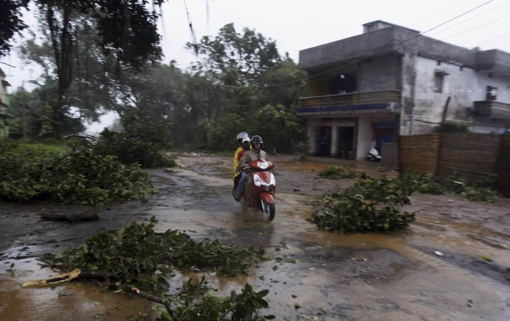 Motorcyclist drives past fallen trees during heavy rain and winds near Gopalpur beach in Ganjam district about 200 kilometers (125 miles) from the eastern Indian city Bhubaneswar.