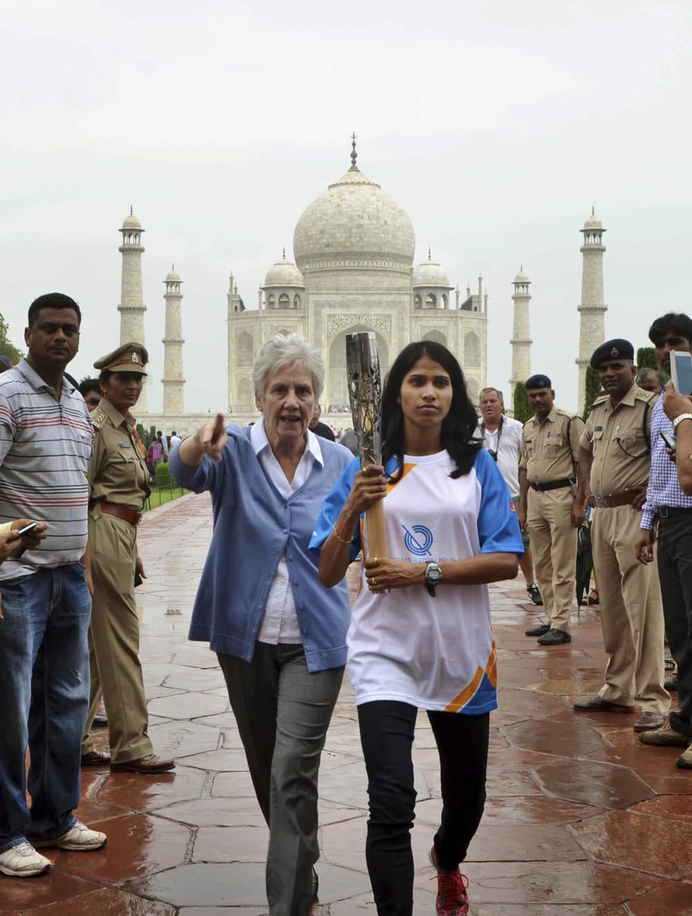 Indian athlete Sudha Singh walks with the Queen’s baton in the backdrop of the Taj Mahal during the baton rally for Commonwealth Games in Agra.