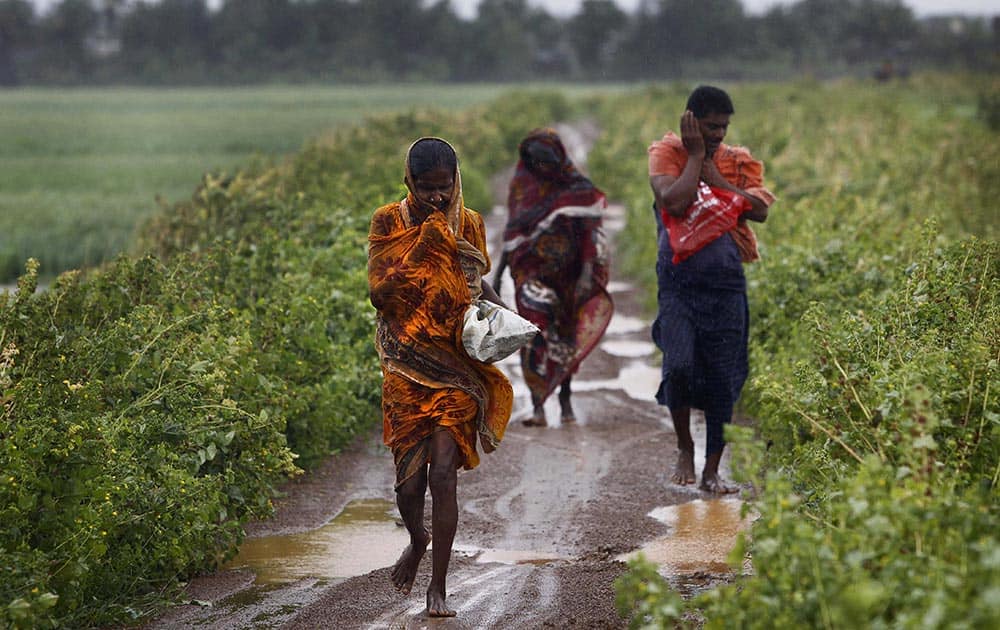 Villagers braving strong winds and rain reach for a cyclone center, in village Podampeta, in Ganjam district about 200 kilometers (125 miles) from the eastern Indian city Bhubaneswar.