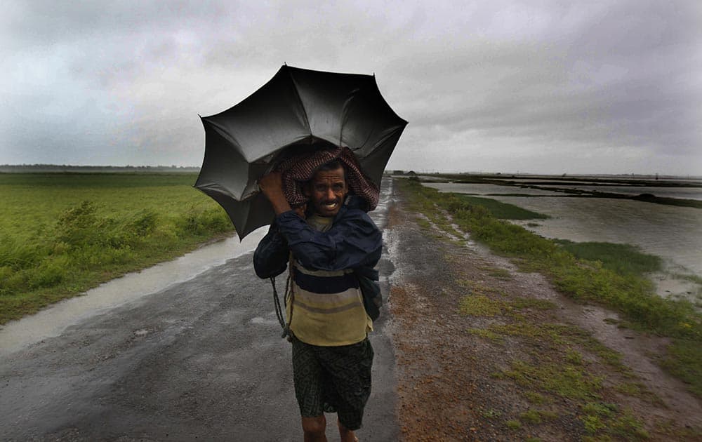An Indian villager braving strong winds and rain walk to a safer place, in village Podampeta, in Ganjam district about 200 kilometers (125 miles) from the eastern Indian city Bhubaneswar.