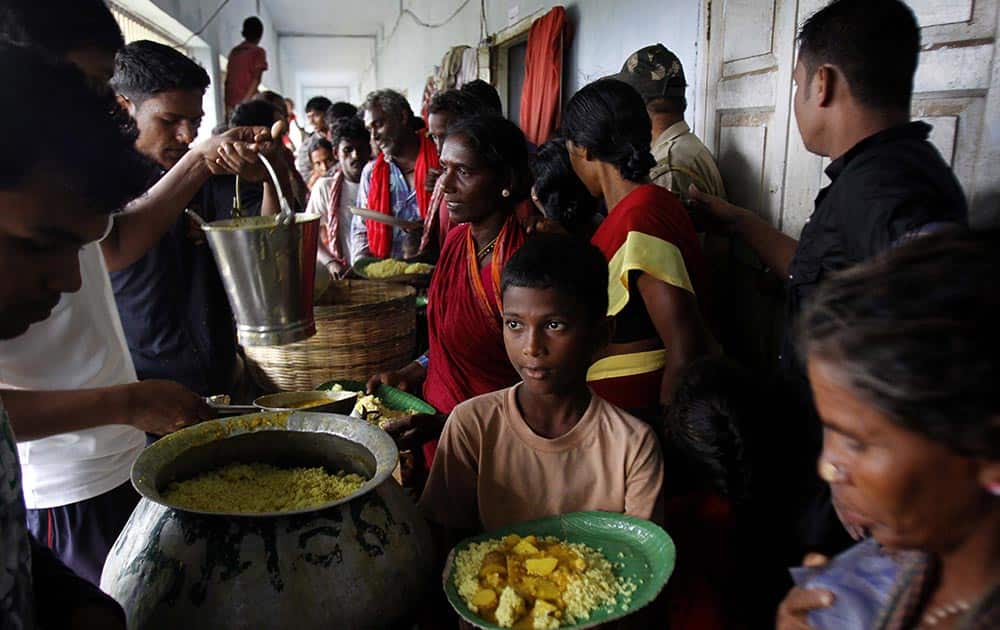 Evacuated Indian villagers eat food at a temporary cyclone shelter in Chatrapur in Ganjam district about 200 kilometers (125 miles) from the eastern Indian city Bhubaneswar.