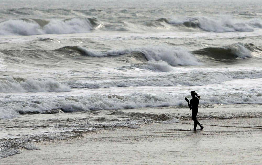A fisherman walks on a beach during a cyclone alert on the Bay of Bengal coast at Puri, Odisha state.