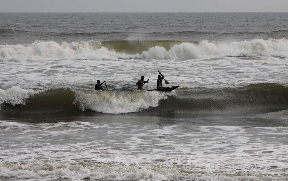 Fishermen on a country boat negotiate the waves as they return with their catch on the Bay of Bengal coast at Puri, Odisha state.