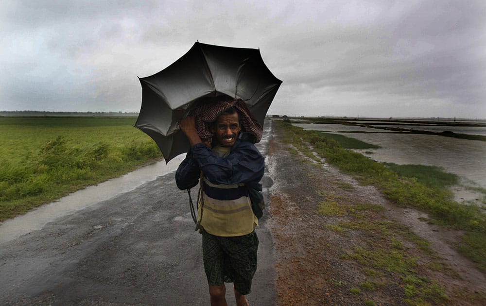 A villager braving strong winds and rain walk to a safer place, in village Podampeta, in Ganjam district about 200 kilometers from the eastern Indian city Bhubaneswar.