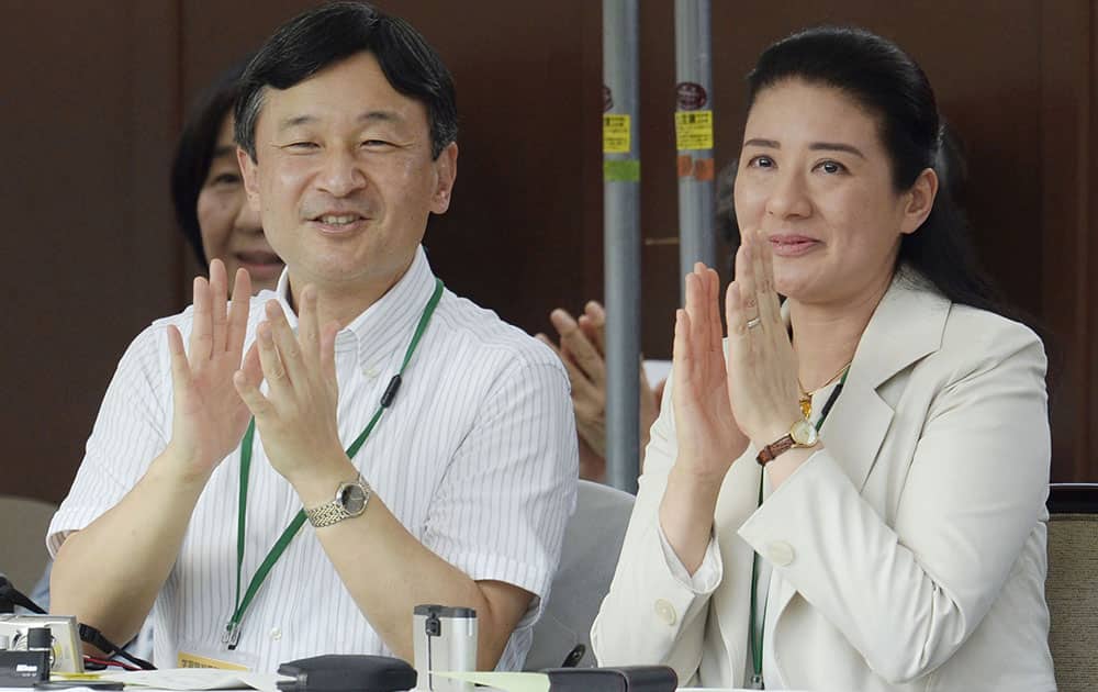 Japanese Crown Prince Naruhito and his wife Crown Princess Masako applaud as they watch their daughter Princess Aiko performing group gymnastics with other pupils at the Gakushuin elementary school in Tokyo during the school`s athletic festival.