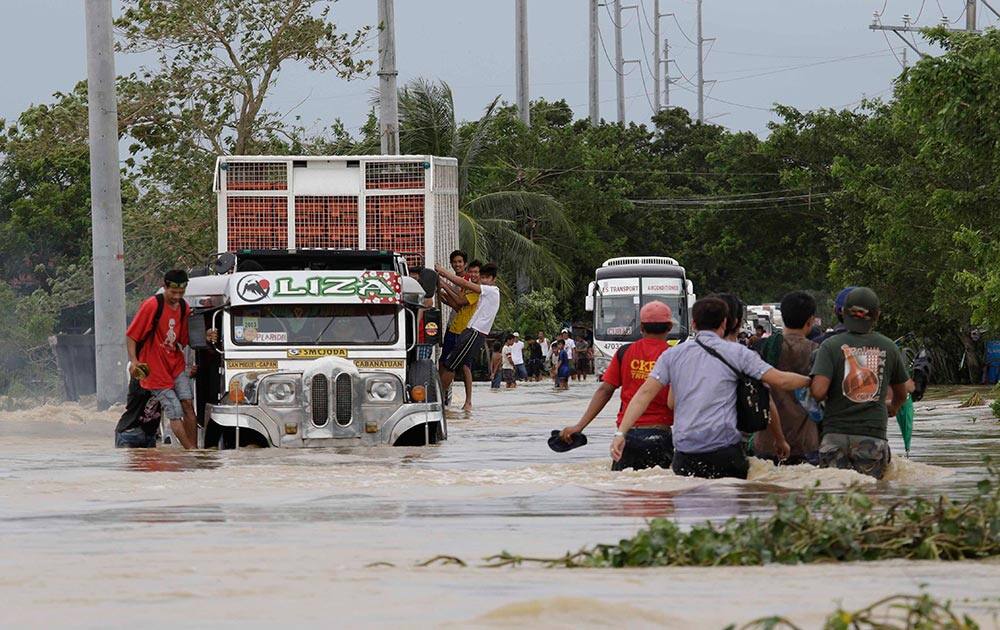 Residents brave the raging floodwaters brought about by Typhoon