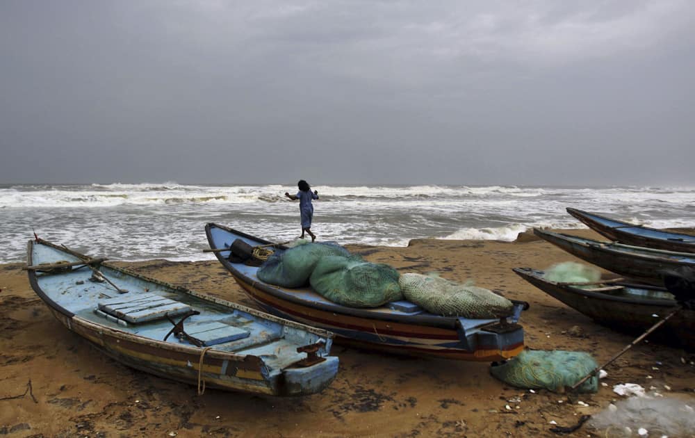 A young Indian girl plays on top of an anchored boat at the Bay of Bengal coast in Gokhurkuda in Ganjam district 215 kilometers (136 miles) away from the eastern Indian city of Bhubaneswar.