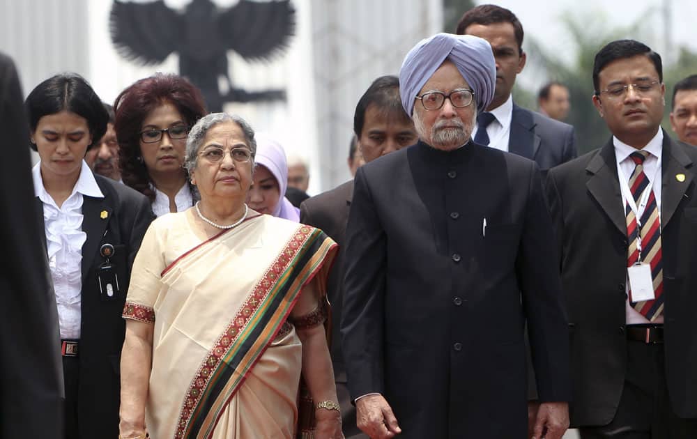 Prime Minister Manmohan Singh, walks with his wife Gursharan as they leave a wreath laying ceremony at Kalibata Heroes Cemetery in Jakarta, Indonesia.