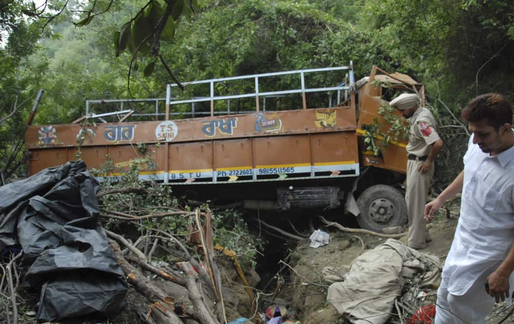 A policeman inspects the wreckage after a truck carrying Hindu pilgrims crashed into a gorge in Hoshiarpur, a town 380 kilometers north of New Delhi. Police say at least 20 people were killed and another 35 injured in the accident.