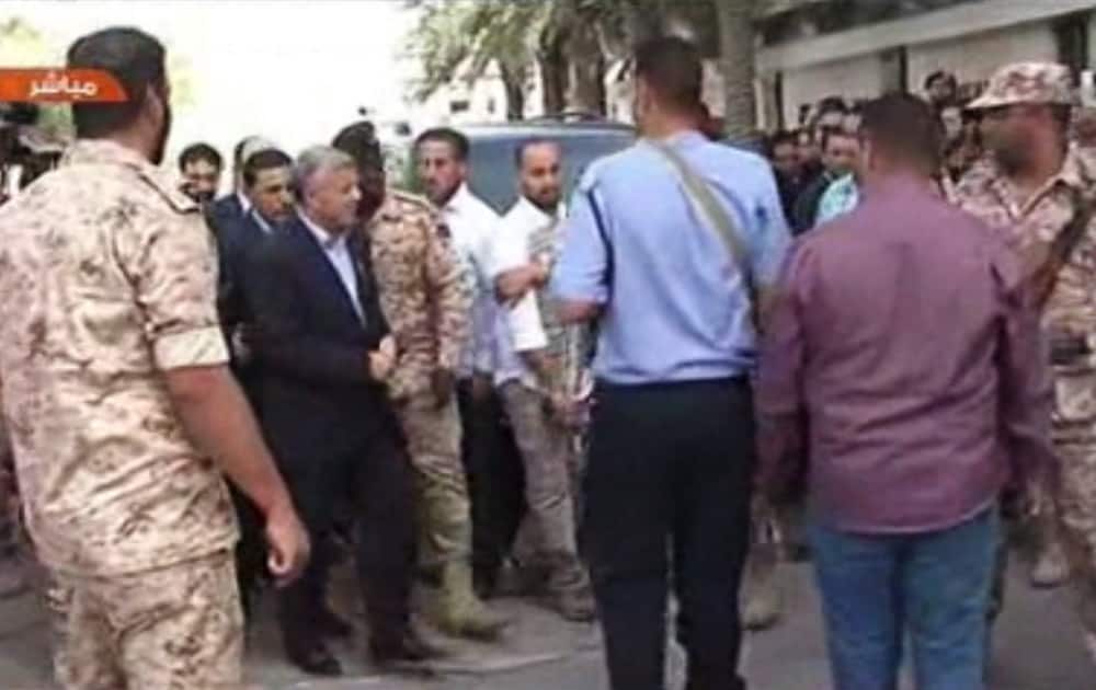 Libyan Prime Minister Ali Zidan appears on a Libyan TV as he arrives at his cabinet office in the capital, Tripoli, Libya. Zidan has appeared in public for the first time since his release after being abducted by gunmen from his hotel earlier in the day.
