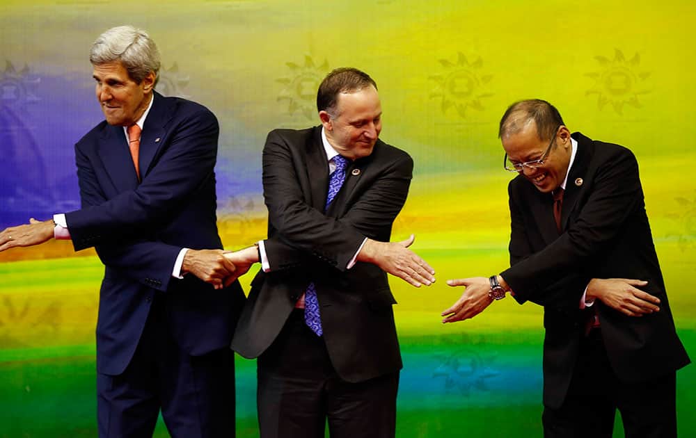 From left, US Secretary of State John Kerry, New Zealand`s Prime Minister John Key and Philippine President Benigno Aquino III join hands as they pose for a group photo at East Asia Summit in Bandar Seri Begawan, Brunei.