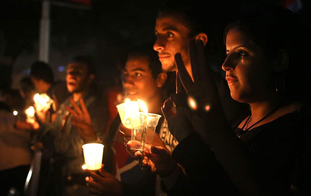 Egyptian protesters light candles during a protest marking the second anniversary of a military crackdown on protesters outside Egypt`s state TV building in Cairo, Egypt.