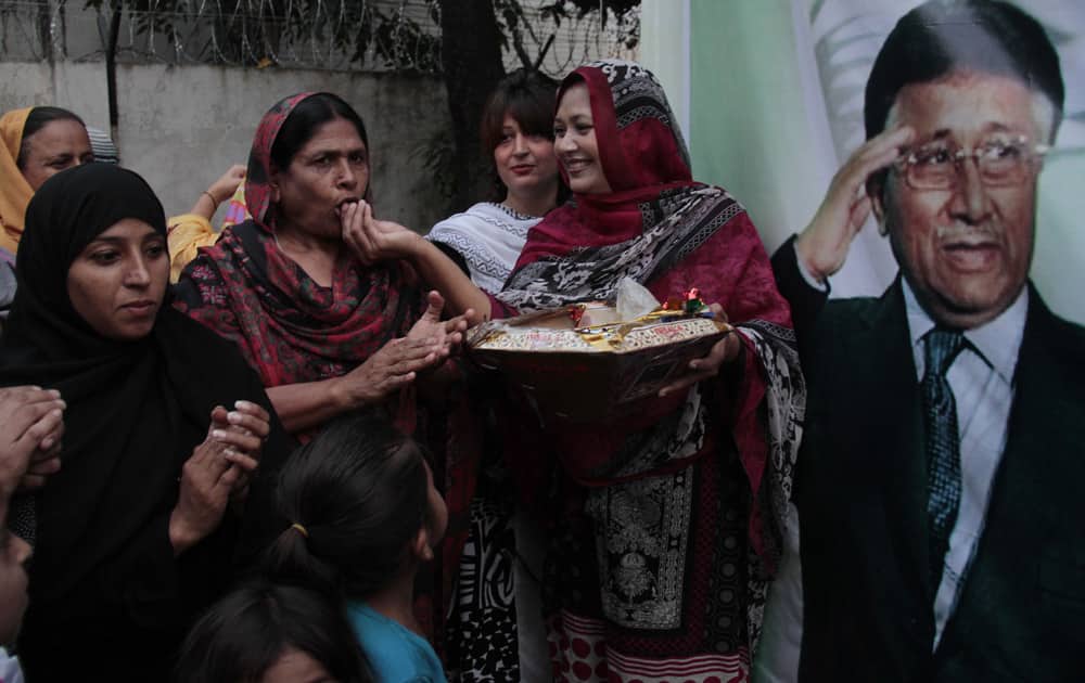 Supporters of former Pakistan President Pervez Musharraf, celebrate the news that a court has granted bail to their leader by exchanging sweets, in Islamabad.