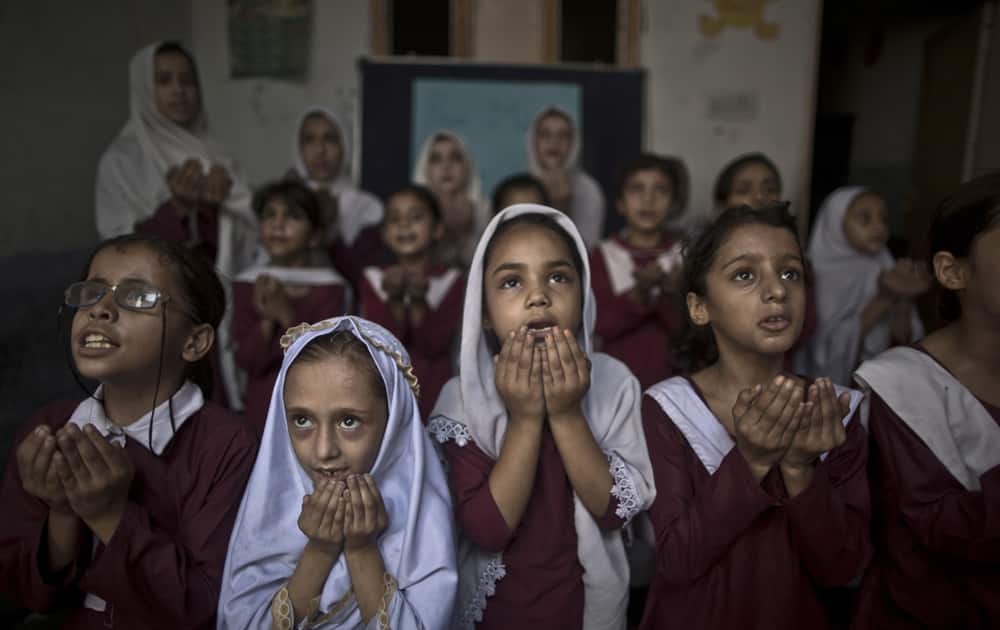 Pakistani school children chant prayers during a special class to recognize the anniversary of Malala`s shooting by Taliban, at a school in Rawalpindi, Pakistan.