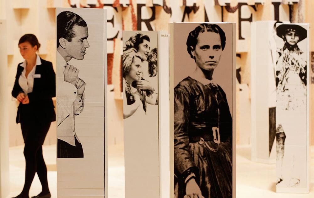 A woman walks along photographs in the Brazilian pavilion on the first day of the Book Fair in Frankfurt, Germany.