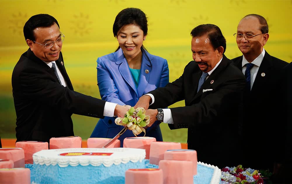 Chinese Premier Li Keqiang joins his hand with Thai PM Yingluck Shinawatra, Brunei Sultan Hassanal Bolkiah for a cake cutting ceremony to mark the 10th anniversary of ASEAN-China strategic Partnership for Peace and Prosperity as Myanmar President Thein Sein looks on before the 16th ASEAN - China Summit.