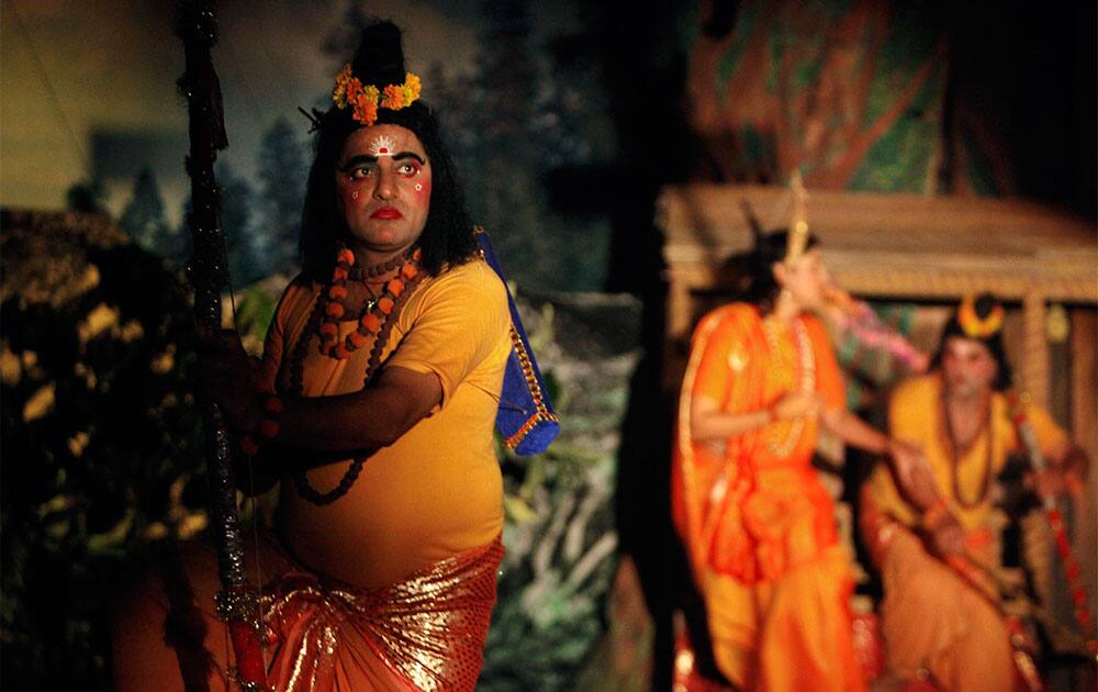An artist in the role of Hindu god Laxman, left, performs the traditional Ramleela drama, narrating the life of God Rama, on stage during celebrations to mark Dussehra festival in Jammu.