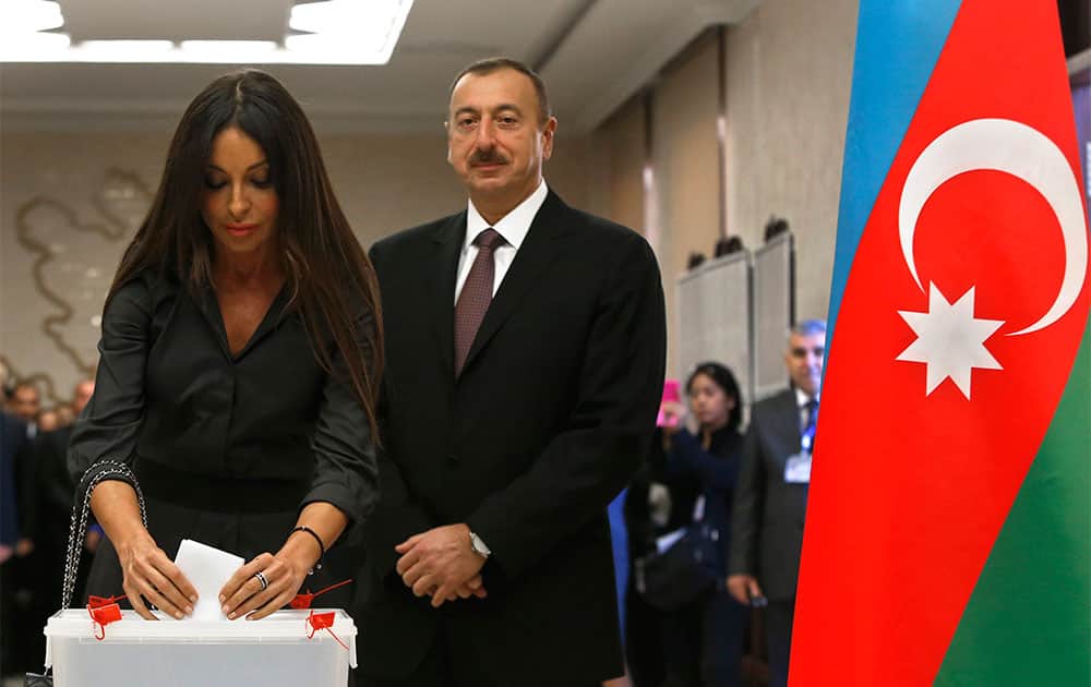 Azerbaijan President Ilham Aliyev, right, looks on as his wife Mehriban casts her vote at a polling station in Baku, Azerbaijan.
