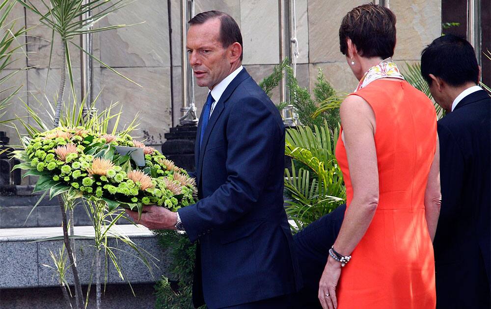 Australian Prime Minister Tony Abbott, left, lays a wreath at the memorial of the 2002 Bali bombing that killed 202 people during his visit at the site in Kuta, Bali, Indonesia.
