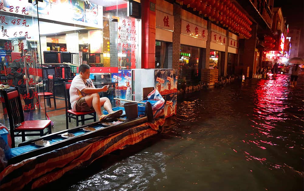A worker rests in his flood hit restaurant in Songjiang district, Shanghai, China. Shanghai city officials closed more than 60 parks and the city zoo as residents waded through flood waters after heavy rains hit the financial hub in the aftermath of Typhoon Fitow.