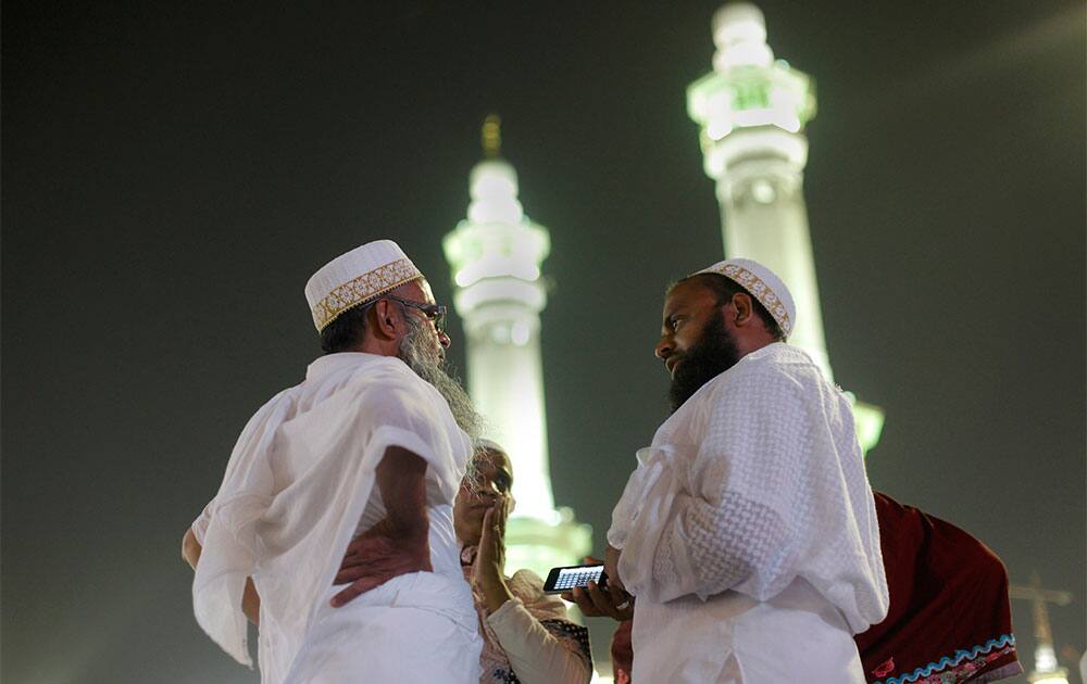 Indian Muslim pilgrims chat in front of the minarets of the Grand Mosque in the holy city of Mecca, Saudi Arabia. The Muslim annual Hajj, or pilgrimage, that will begin on Oct. 14 this year, draws three million visitors each year, making it the largest yearly gathering of people in the world.
