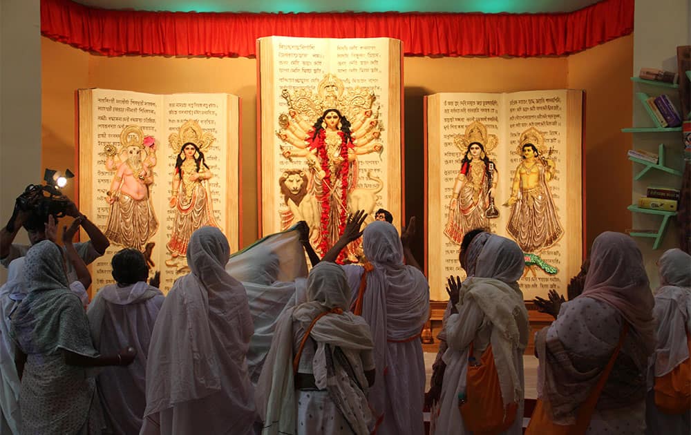 A group of Indian widows from the north Indian town of Vrindavan offer prayers at a worship venue of goddess Durga during their trip to Kolkata by non-governmental organization Sulabh International, in Kolkata.