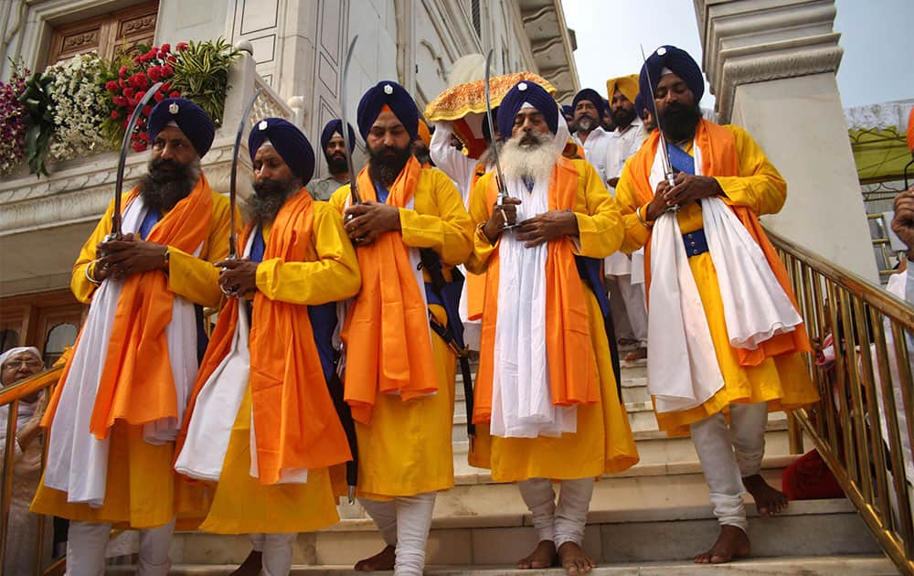 Indian Sikhs dressed as `Panj Pyare` or the five beloved ones walk while holding swords during a religious procession on the eve of birth anniversary of Guru Ram Das in Amritsar.