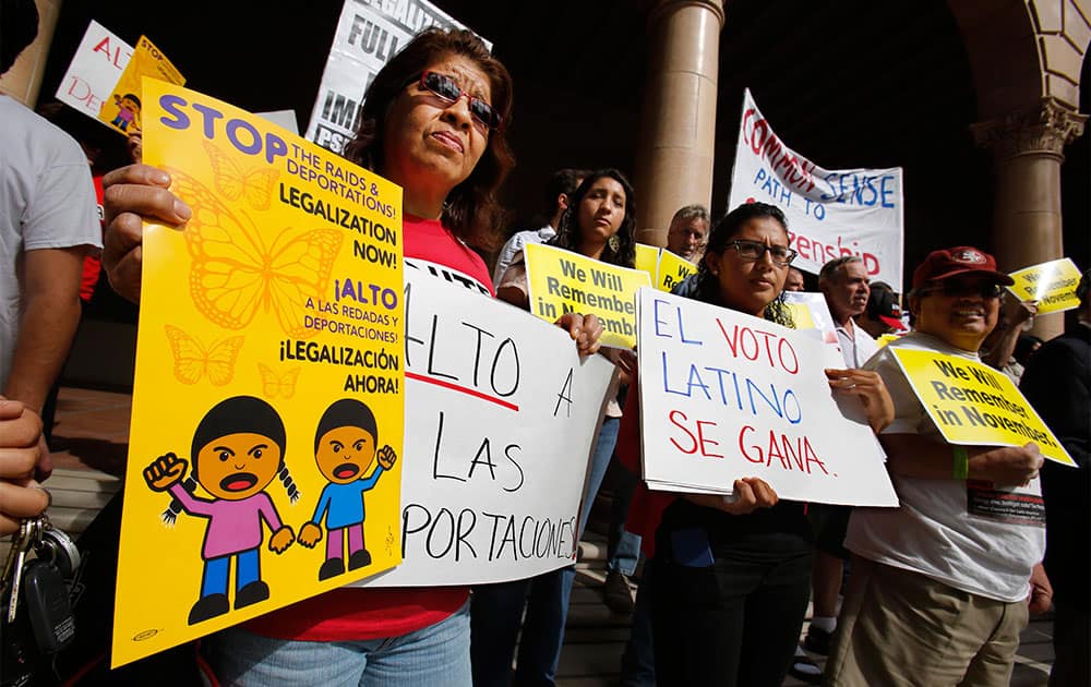 Dora Hernandez, left, joins others in a demonstration outside the building where the state Republican Party Headquarters is located calling on the GOP to support immigration reform, in Sacramento, Calif.