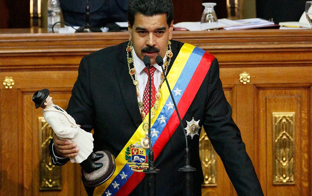 Venezuela`s President Nicolas Maduro, holds a statue of the beloved physician folk-saint Dr. Jose Gregorio Hernandez, as he delivers a speech at the National Assembly in Caracas, Venezuela.