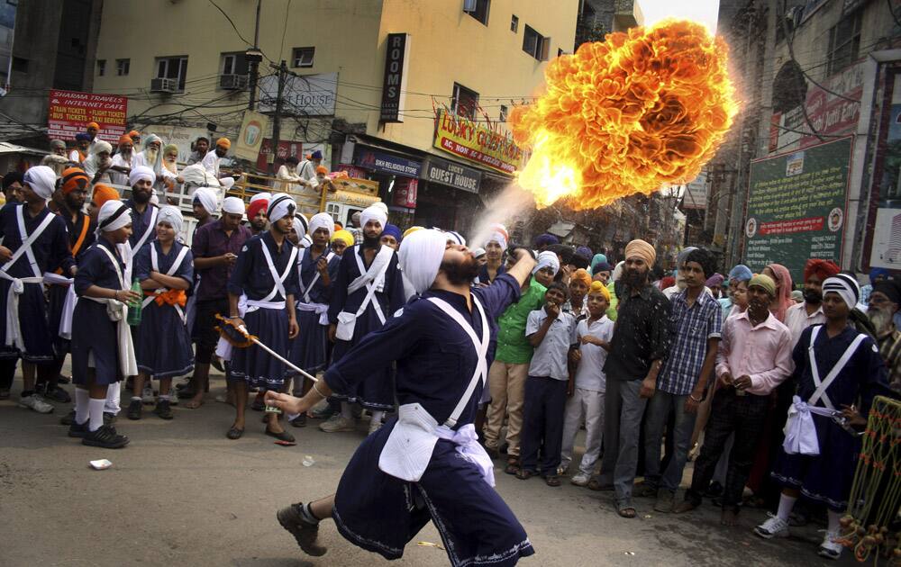 A Sikh youth performs an act of fire as he displays martial art skills during a religious procession on the eve of birth anniversary of Guru Ram Das in Amritsar.