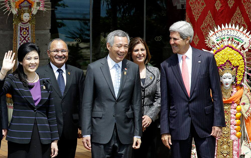 Thai Prime Minister Yingluck Shinawatra, left, waves as, left to right, Papua New Guinean Prime Minister Peter O`Neill, Singapore’s Prime Minister Lee Hsien Loong, Peruvian Foreign Minister Eda Rivas and U.S. Secretary of State John Kerry, stand for a group photo session during the Asia-Pacific Economic Cooperation (APEC) forum in Bali.