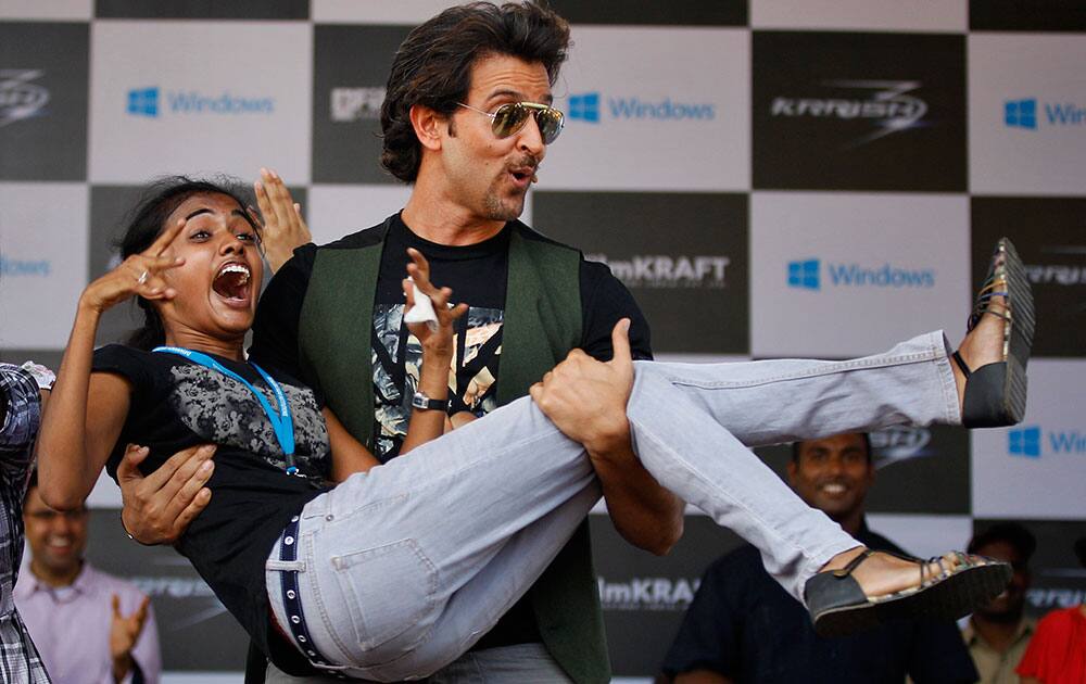 Sushmita, a college student, reacts with joy as she is lifted by Bollywood actor Hrithik Roshan, during an event to promote his forthcoming science fiction movie ‘Krrish 3’ at a college campus in Bangalore.