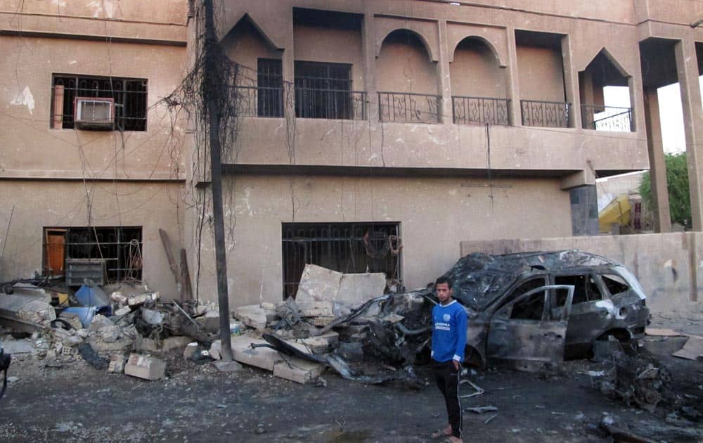 An Iraqi man inspects the aftermath of a bombing in the Baghdad al-Jadidah district, a mixed area under the control of Shiite militias in Baghdad.