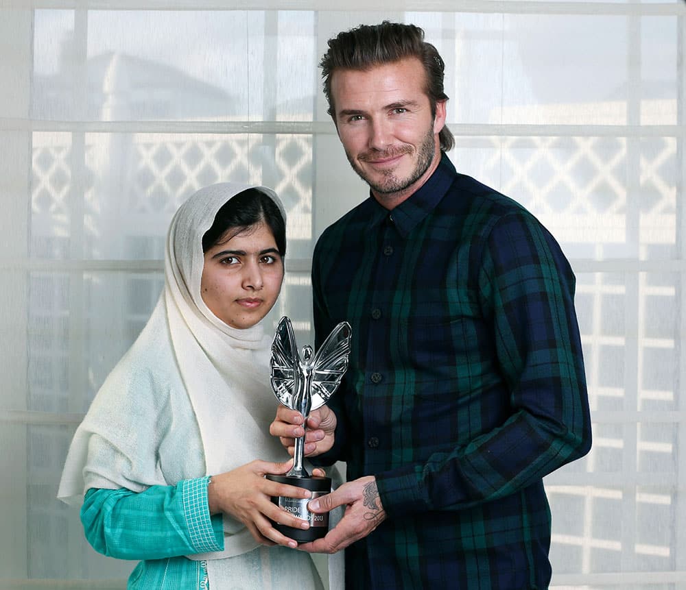 David Beckham presents a Mirror Pride of Britain Teenager of Courage Award to Malala Yousafzai, a Pakistani schoolgirl who was shot by the Taliban for going to school.