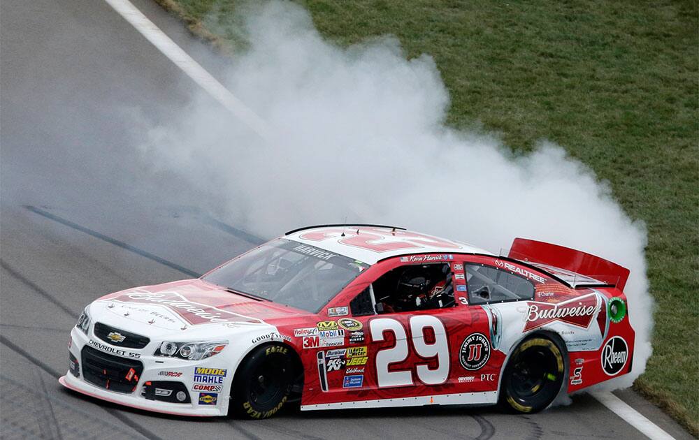 Driver Kevin Harvick does a burnout as he celebrates after winning a NASCAR Sprint Cup series auto race at Kansas Speedway in Kansas City, Kan.